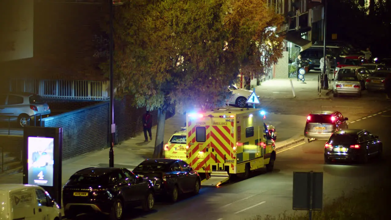 Panning shot following an ambulance with flashing lights in London England