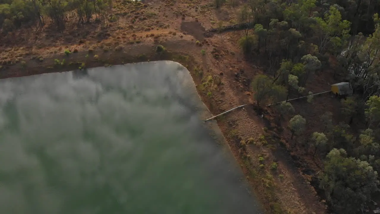 Overview drone shot of a damlake in the outback in Australia With reflections in the water and pipeline