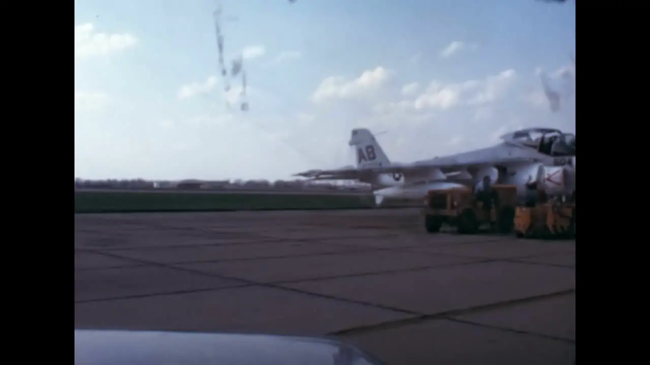 A truck stops near a parked fighter to refuel it