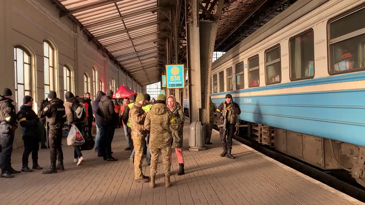 A train full of refugees ready to leave the Lviv Train Station with soldiers and police standing by