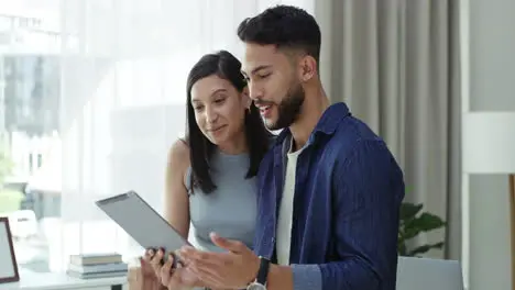 Young couple remote working at home on a tablet