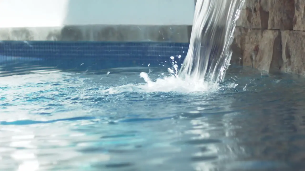 Artificial waterfall cascading over the water of a relaxing spa pool