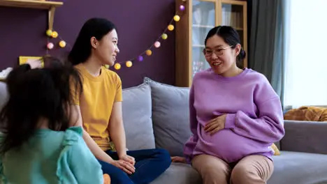 Asian mothers talking in living room