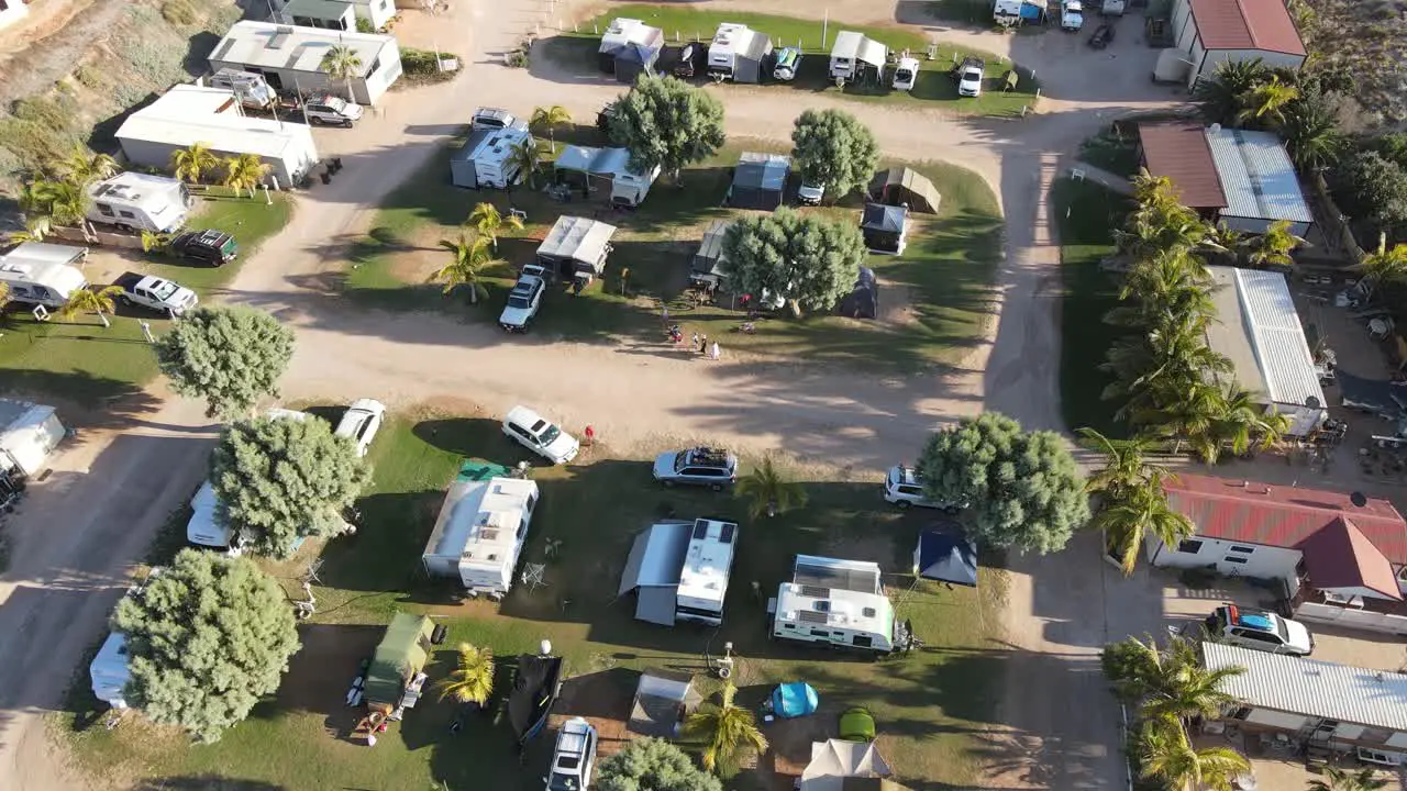 4K Family arriving caravan park at sunset holiday time aerial shot slow motion 60fps