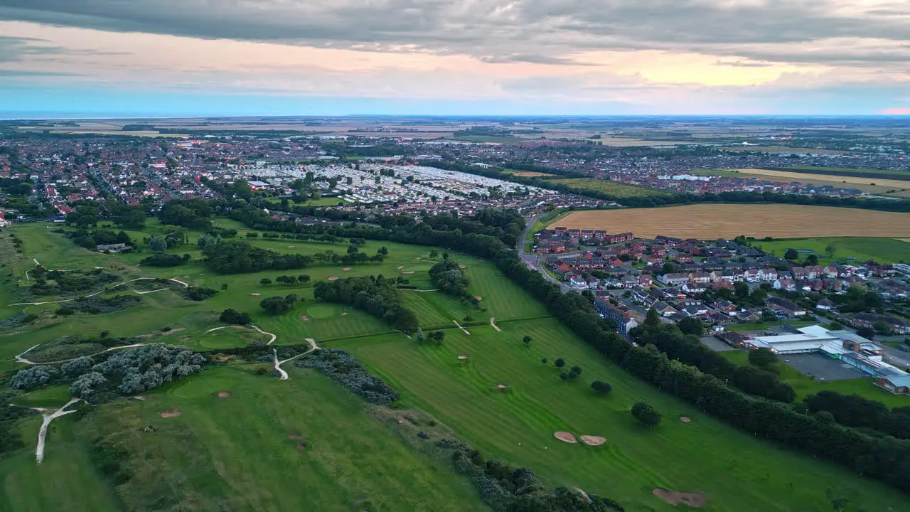 Aerial drone video captures Skegness by the sea at sunset showcasing holiday park beach sea and caravans on sweeping landscapes