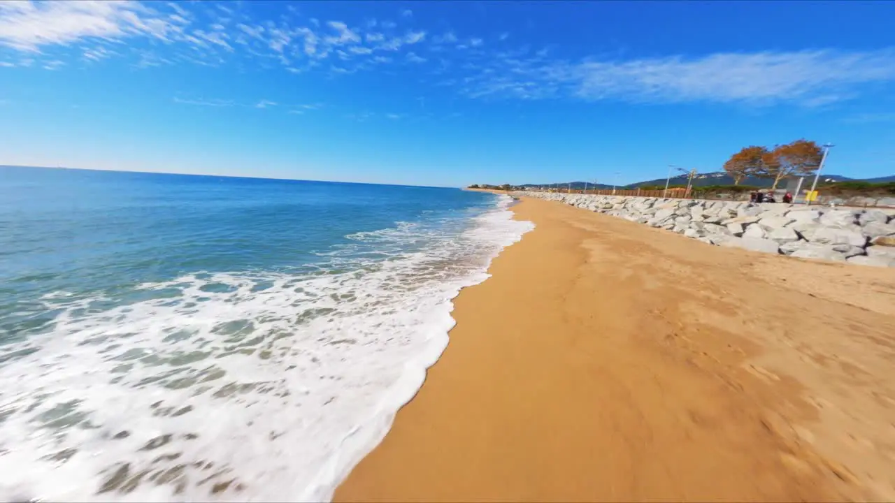 FPV aerial drone flying fast along a picturesque Mediterranean beach along the coast of Spain