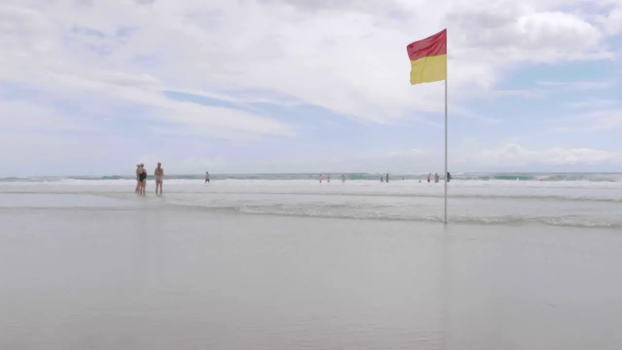 Red and Yellow Flag Blowing in the wind on Beach