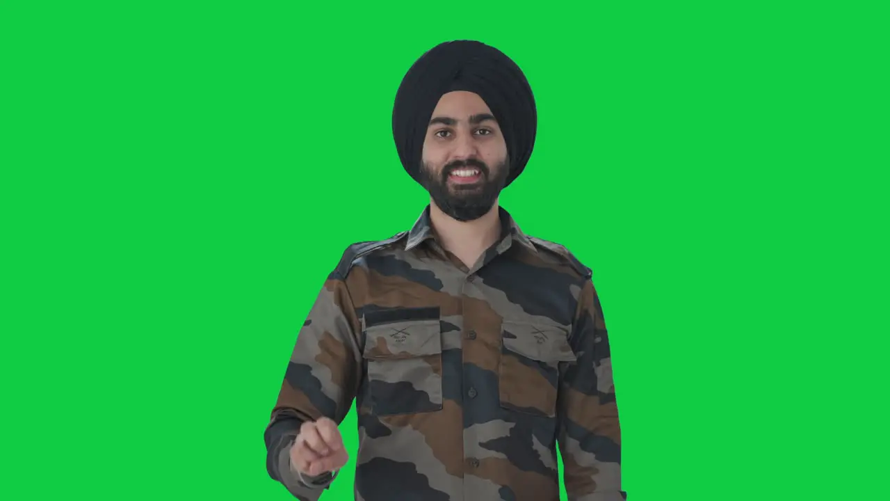 Happy Sikh Indian Army man showing victory sign Green screen