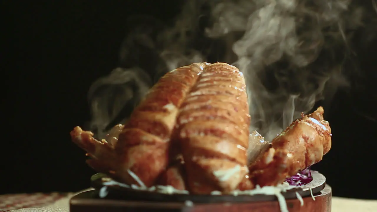 Close Up Of Roasted Chicken Bbq on Round Table With Smoke Black Background