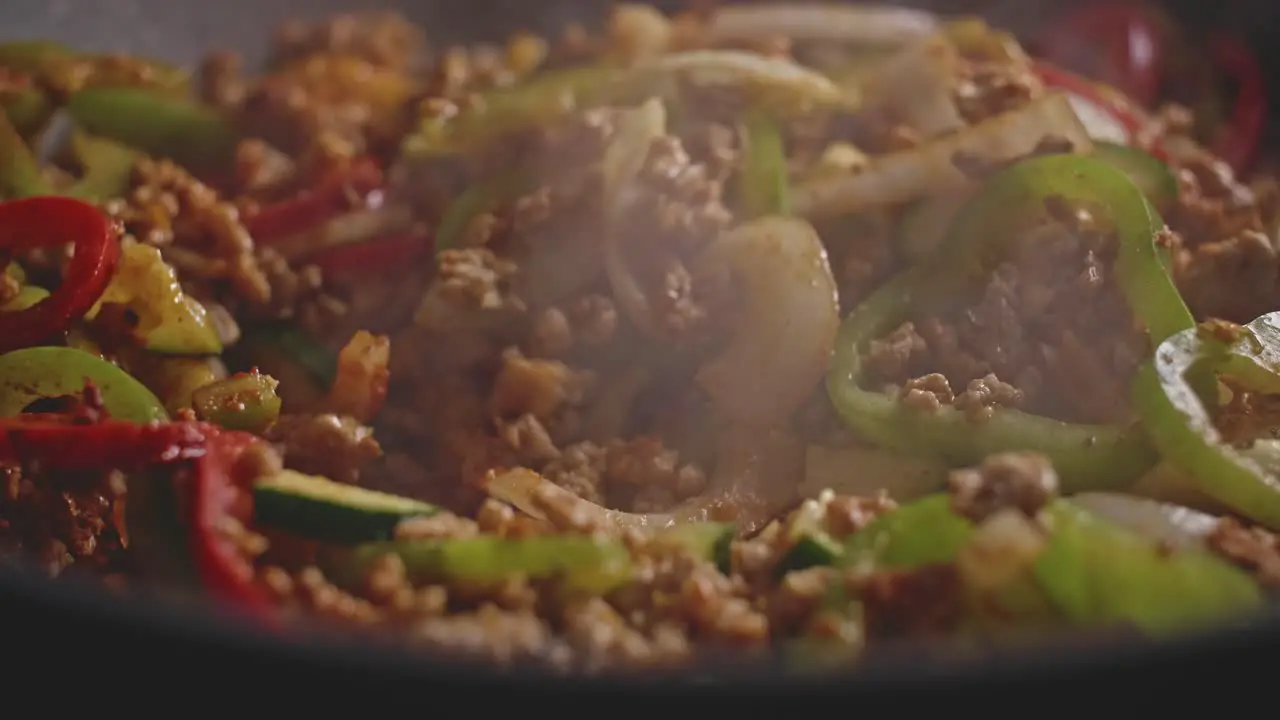 Macro shot of meat and vegetables in a wok cooking homemade mexican food