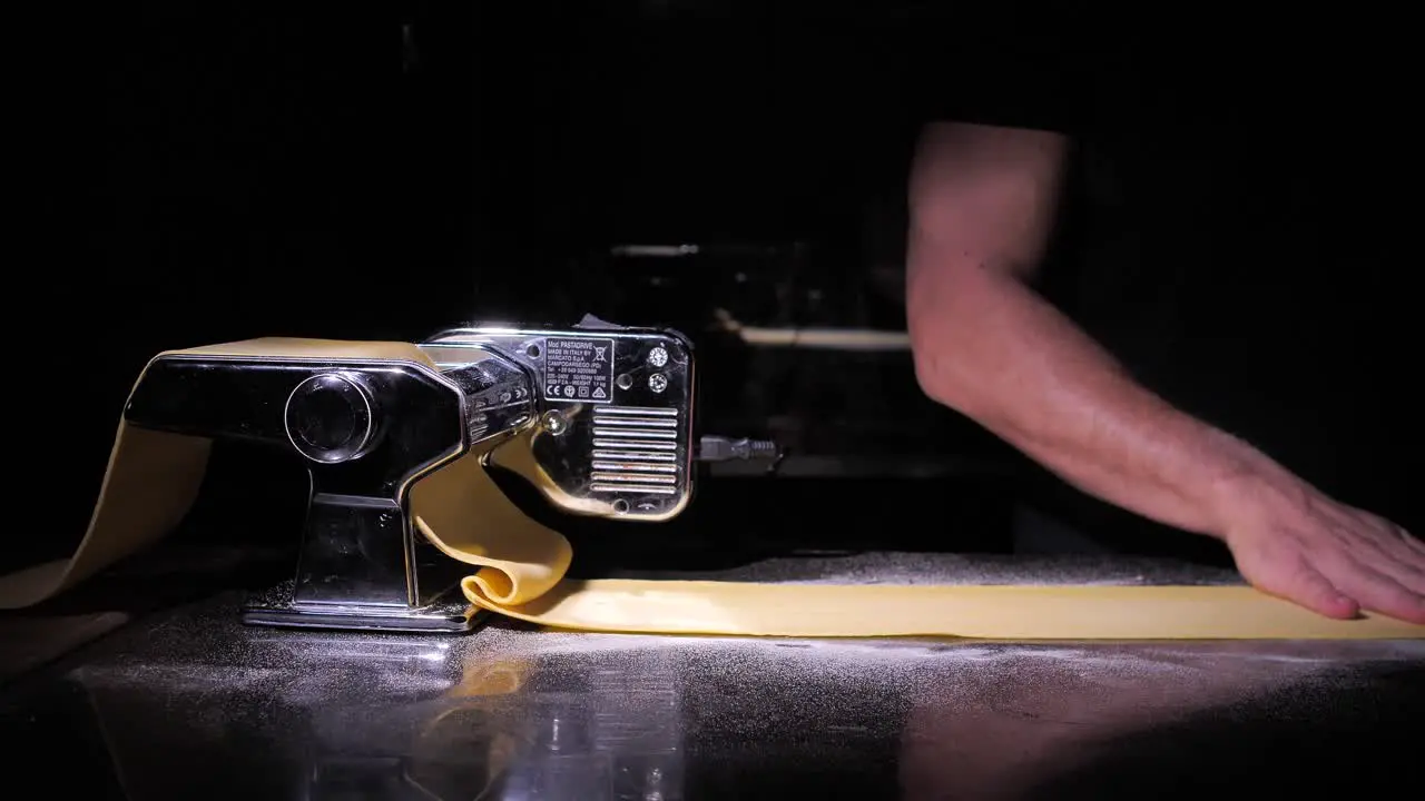 Unrecognizable man making fresh homemade lasagne pasta isolated on black background