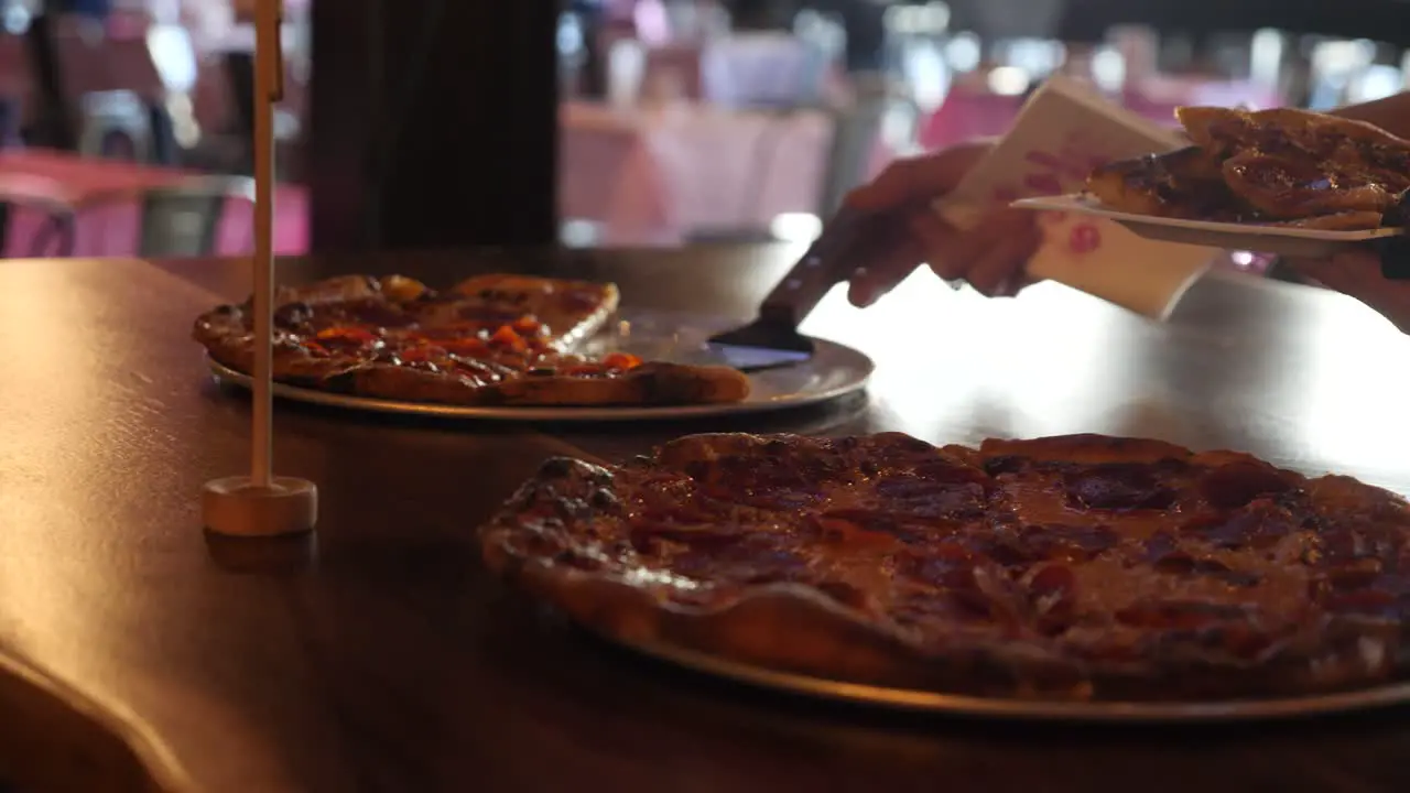 Person Grabbing a Slice of Pizza in Slow Motion