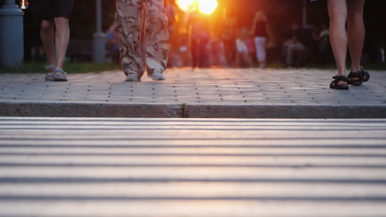 People Walk In The Evening City At Sunset In The Frame You Can See The Man's Togas In Camouflage Pan