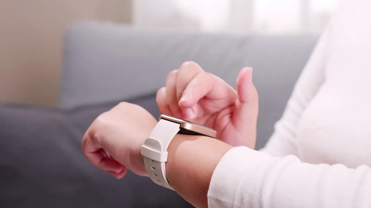 Close up shot of a woman hand who touch and scrolling on a smartwatch in order to quickly check application connect