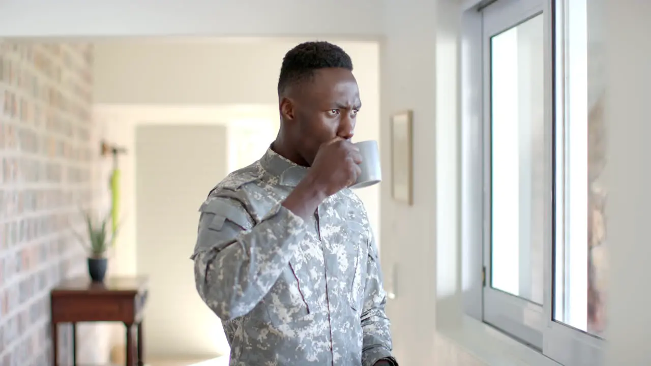 Young African American soldier holding a coffee mug at home with copy space