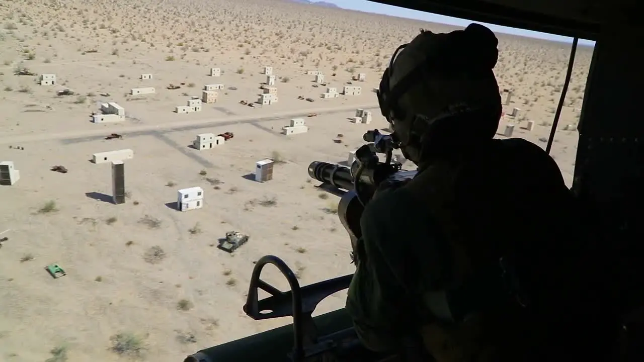 An Army Soldier Fires A Machine Gun From A Huey Helicopter At A Model Arab Village In This Training Session