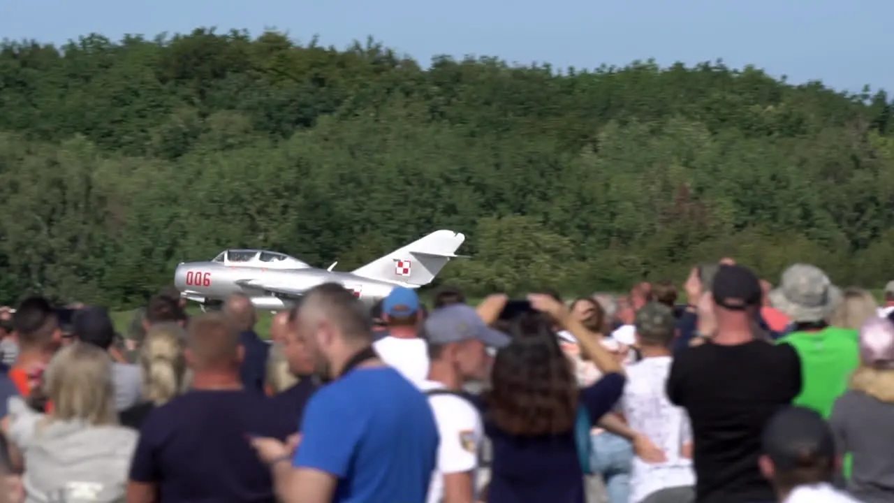 Crowd looking lim-2 plane on the Aerobaltic airshow 2021 taking off from the runway