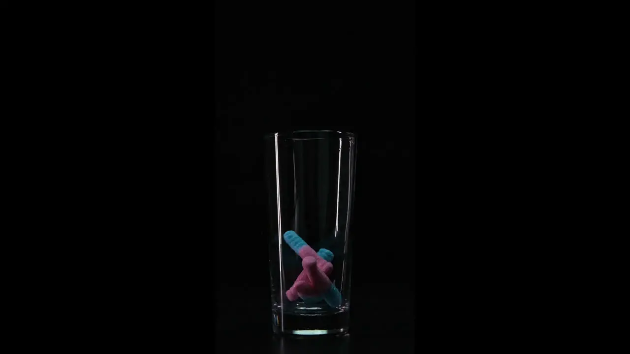 Candy falling down in empty glass Slowmotion