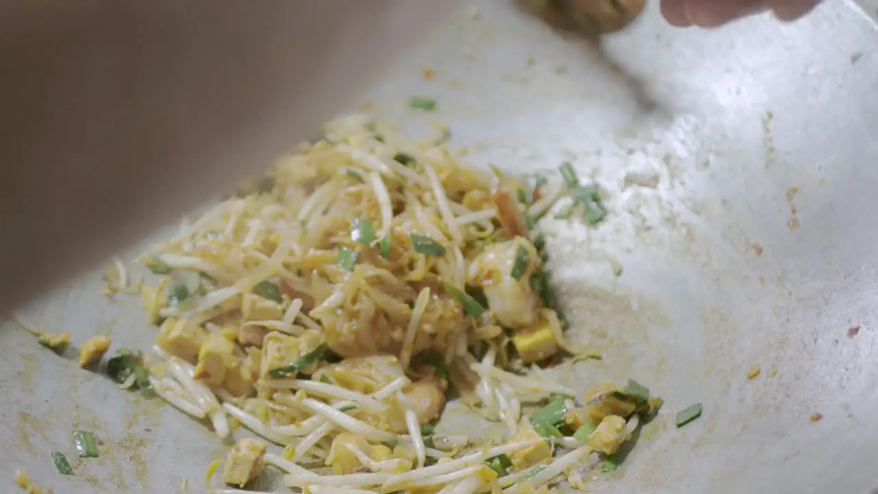 White Asian noodle bean sprout and shrimps while being cooked and stir fried in the pan preparing to make Pad-Thai