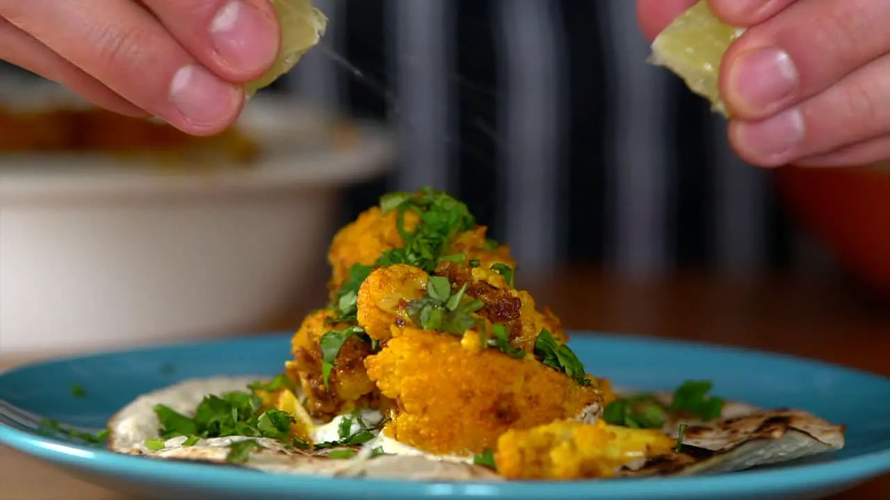 Man Chef squeezing limes on top of the most delicious cauliflower tacos