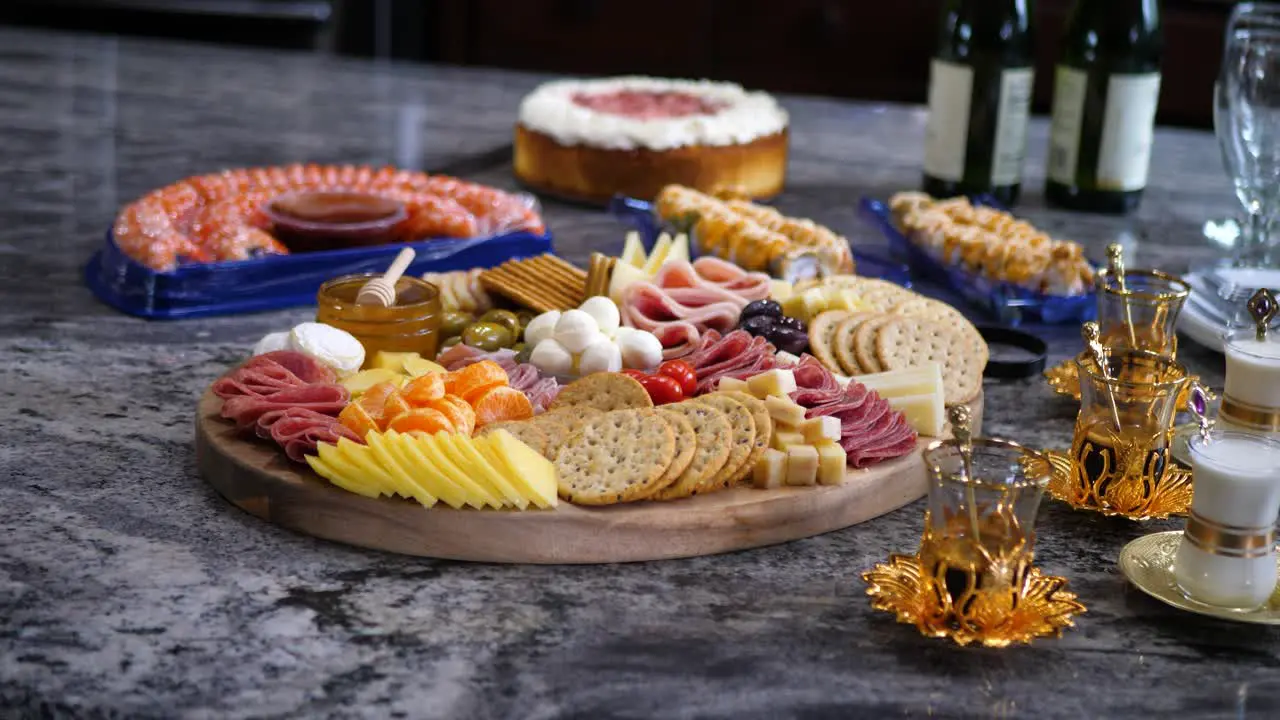 Finger food charcuterie board platter with mixed foods like ham cheese and crackers