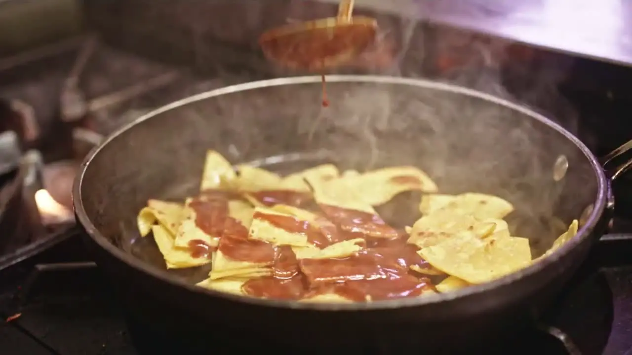 Pouring Red Sauce on Frying Nachos in a health Vegan Mexican Kitchen