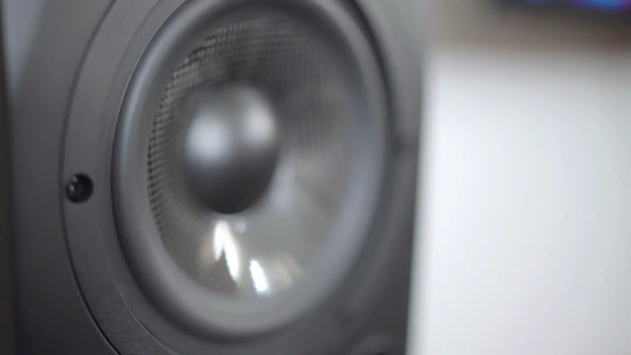 Dolly into a close up of a studio speaker coming into focus