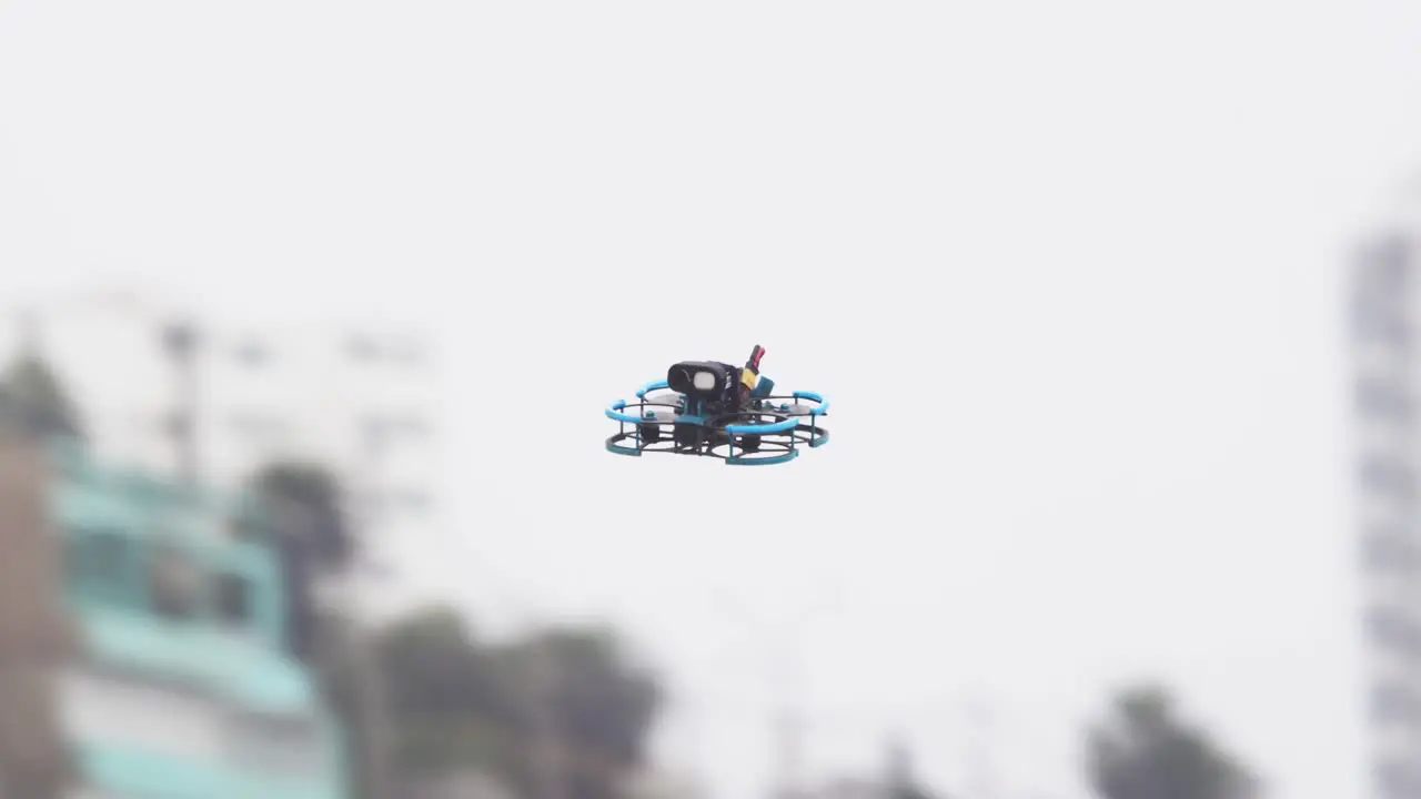 Tracking shot of a FPV drone as it moves across a urban landscape