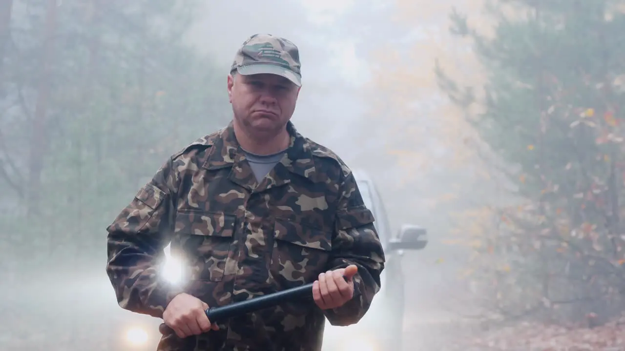 Portrait Of An Angry Security Guard In Camouflage Uniform With A Rubber Baton In His Hands