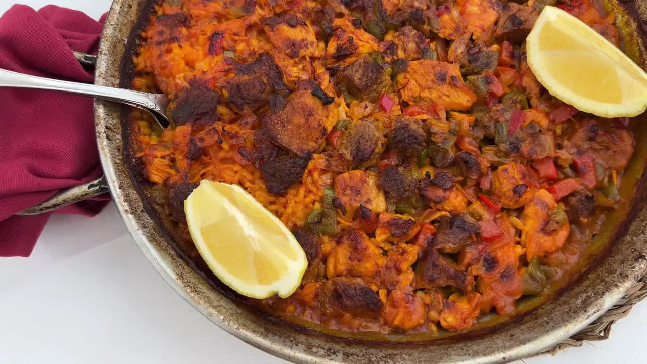 Traditional Spanish Paella dish with chicken vegetables and lemon slices in a restaurant tasty seafood in Marbella Spain 4K shot