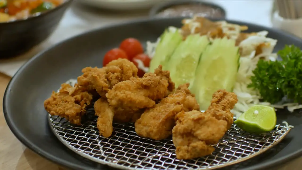 POV to the chicken karaage japanese food while using chopstick picking up from the plate