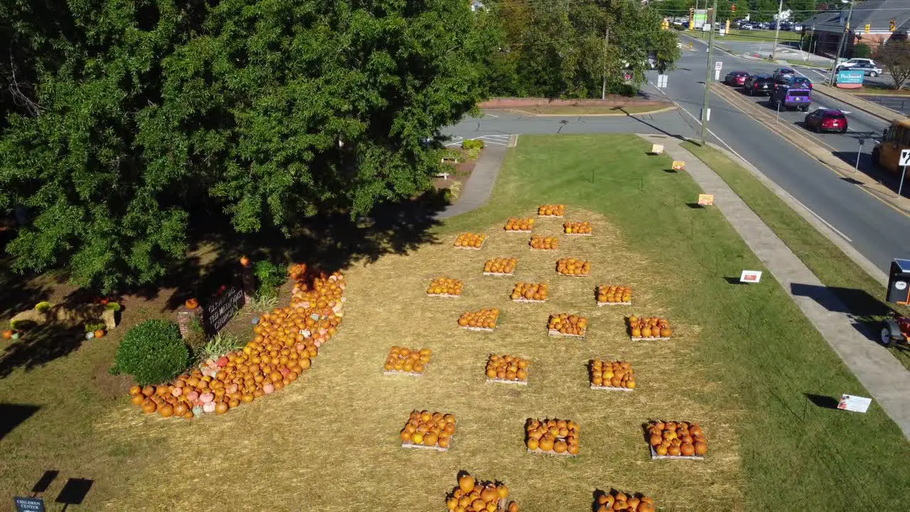 Backwards aerial shot of pumpkin patch at church