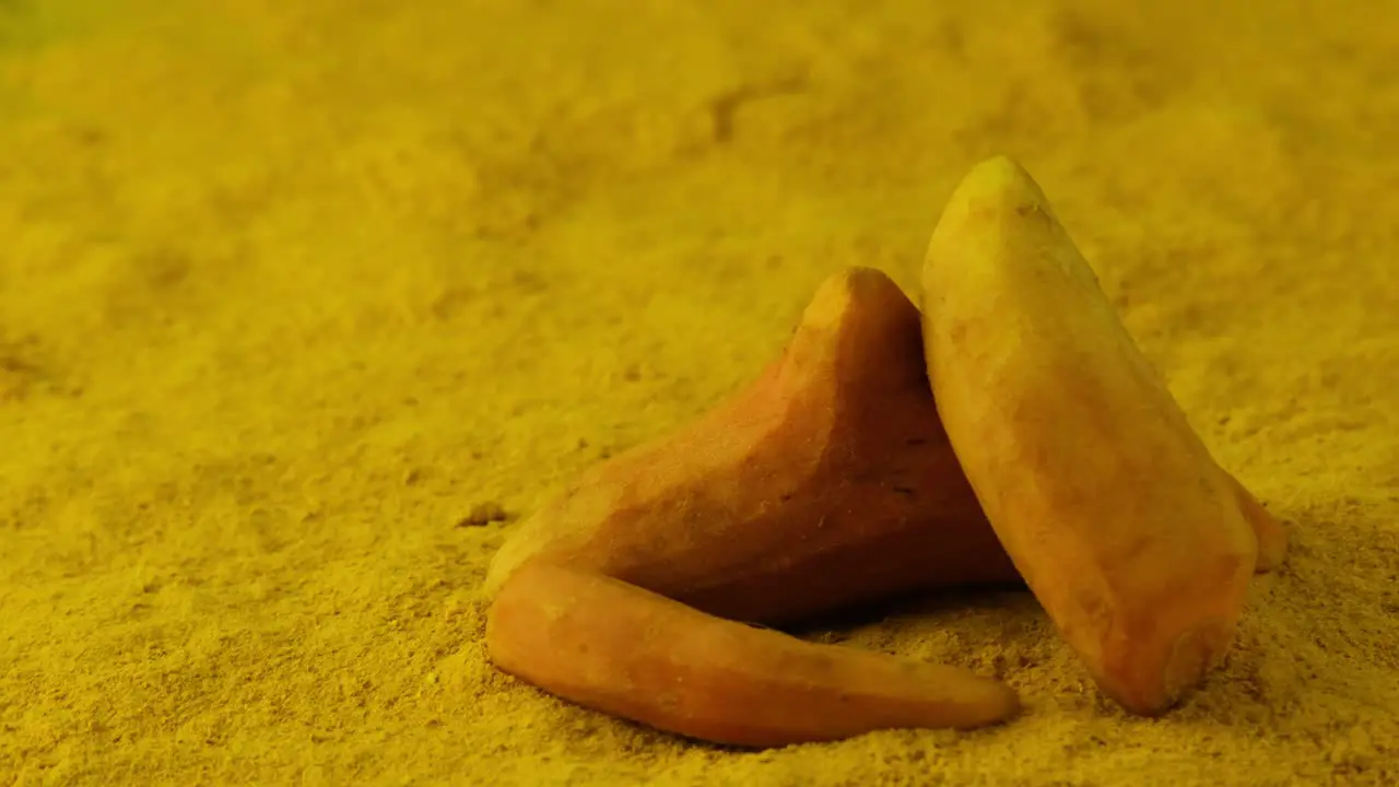 Rotating Shot of Three Sweet Potatoes Placed on a Bed of Yellow Powdered Spices