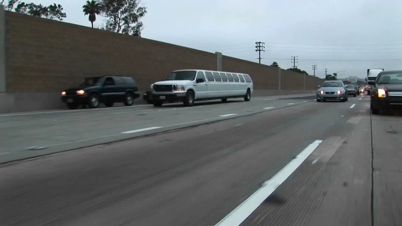 A stretch limo drives down a freeway