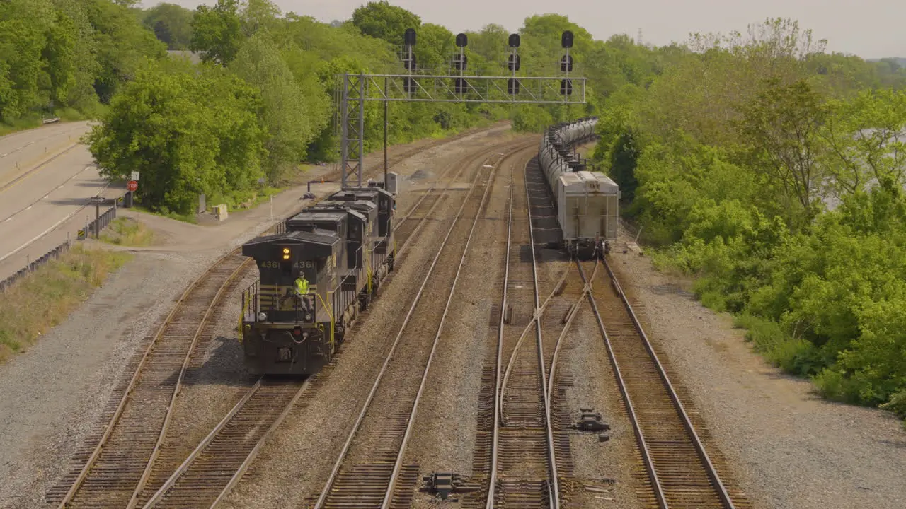 trains engine backing up on the railroad tracks with another train pulling away