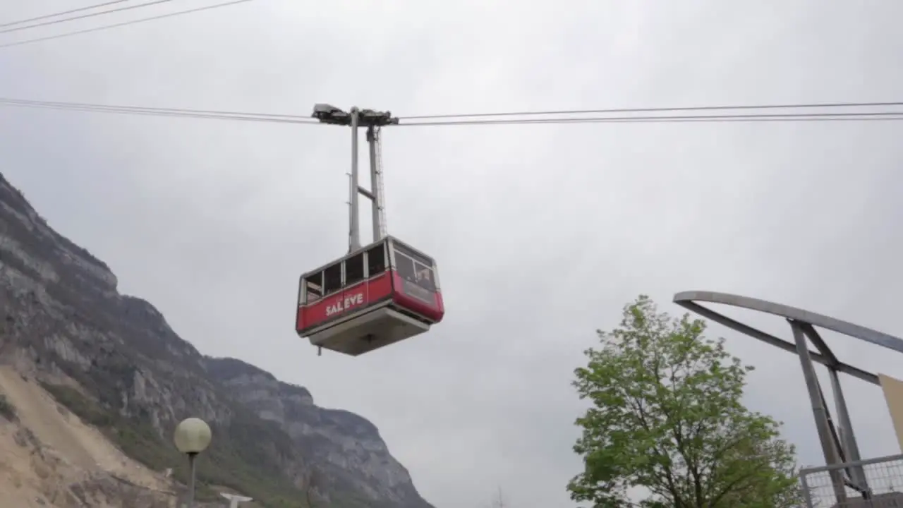 Salève cable-car coming down on overcast day panning low angle shot