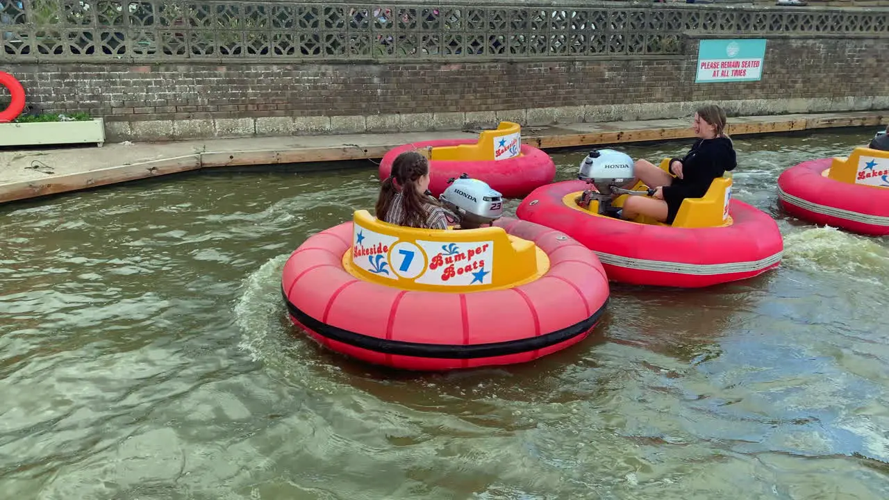 Children playing in bumper boats on the water at a holiday theme park