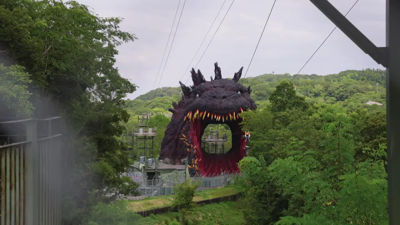 Japanese Person Ziplines Towards Giant Godzilla Mouth