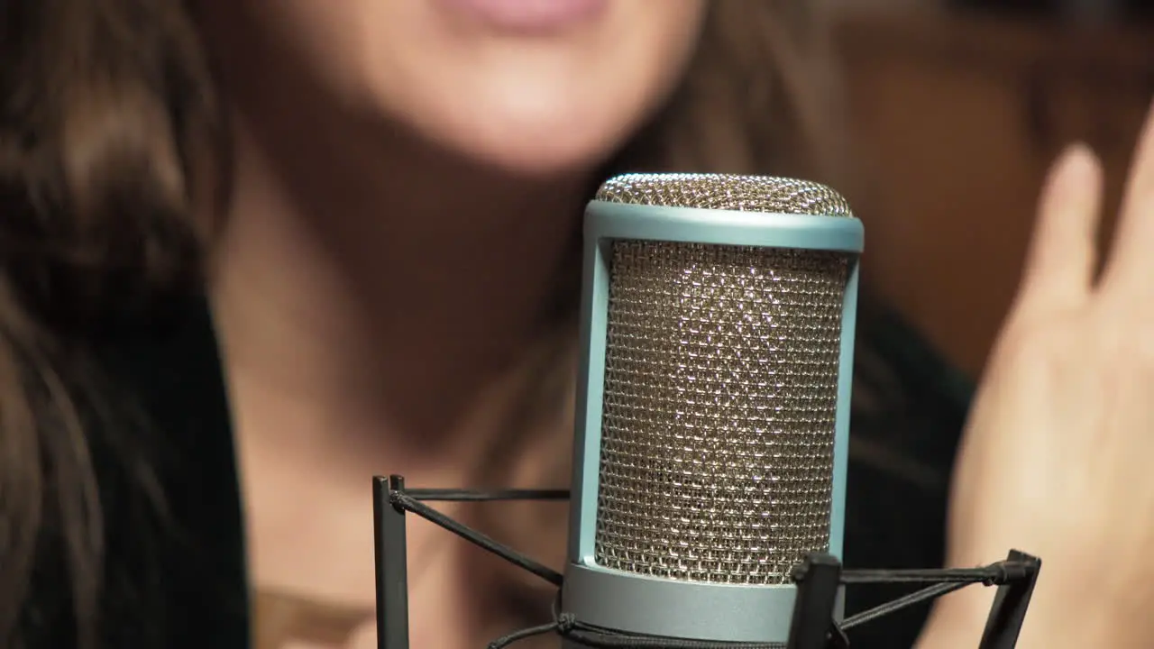 Woman radio host sitting at microphone and having talk on air about news