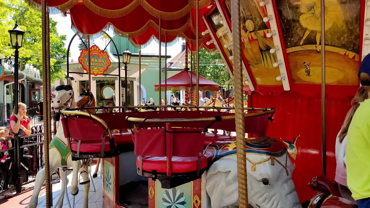 People having fun riding classic carousel in Grona Lund Tivoli in Stockholm Sweden