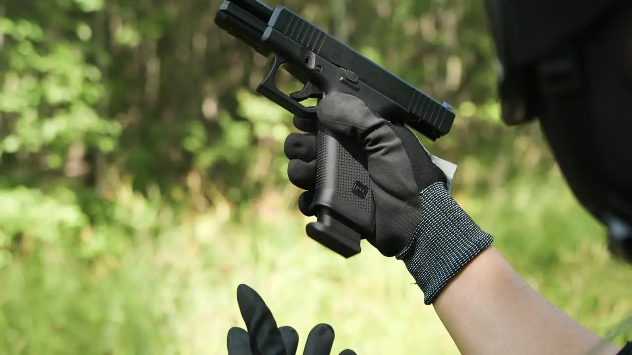 Army guy reloading pistol magazine with gloves