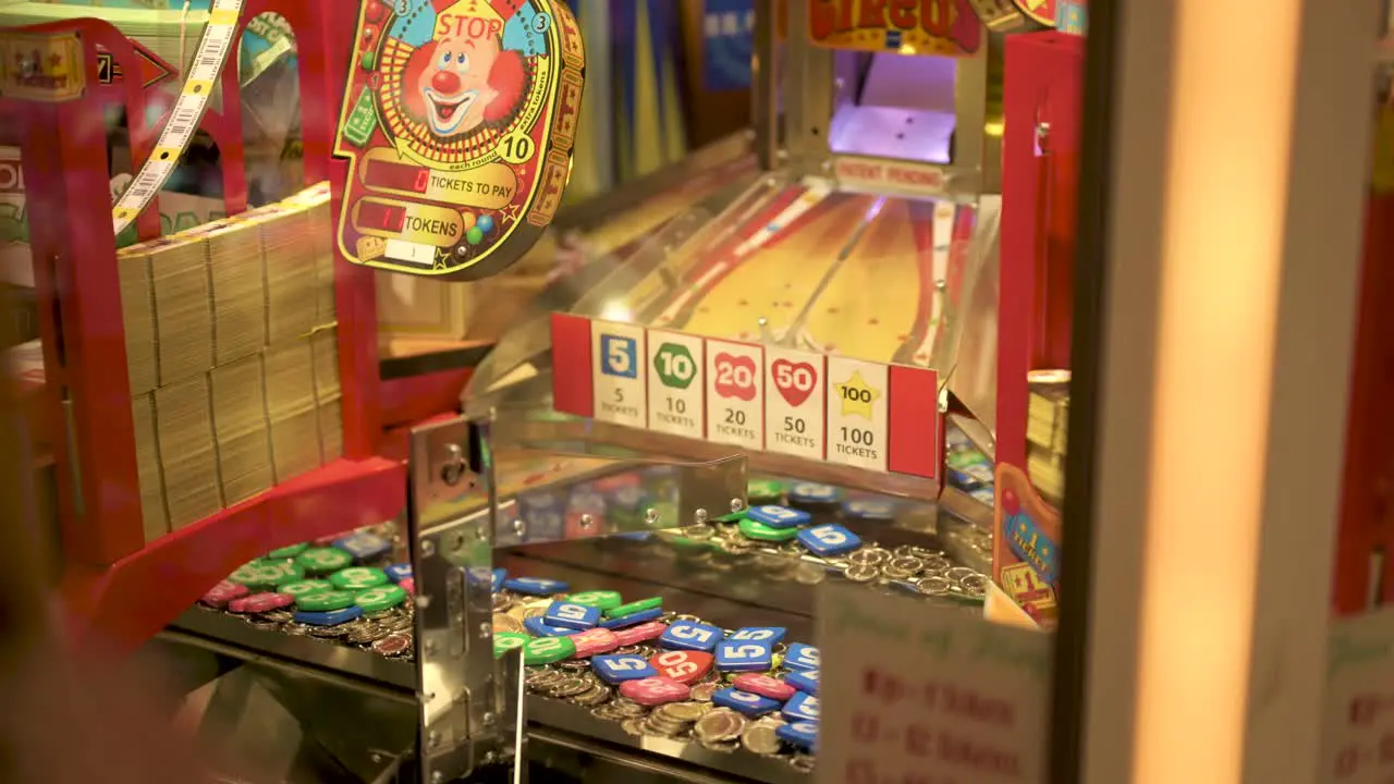 Arcade coin pusher woman pointing at where to drop the coin slow motion