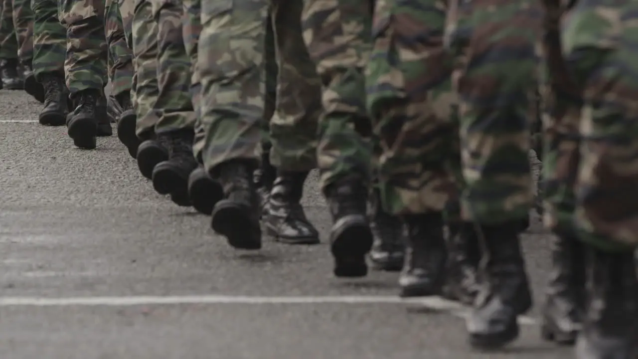 Many men marching in boots and army clothing