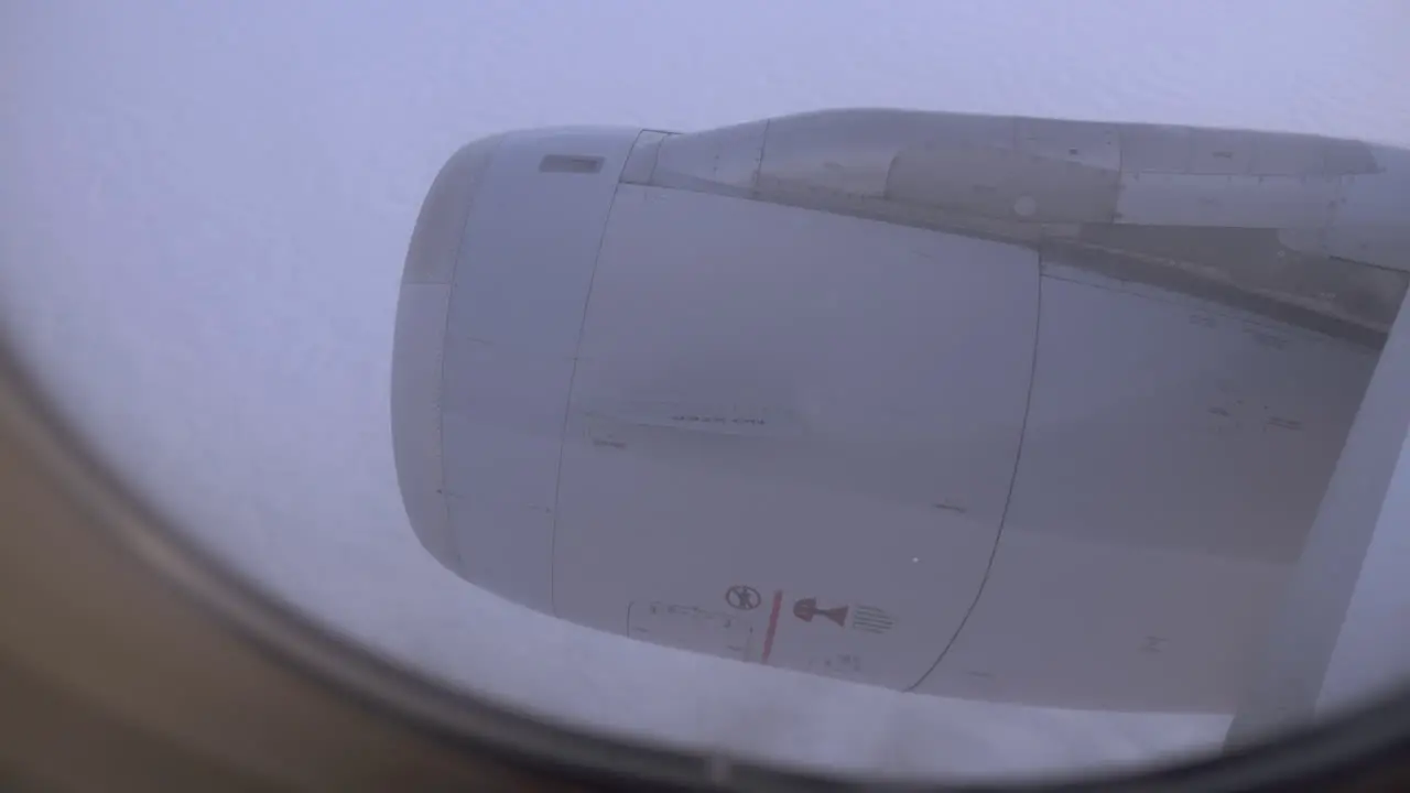 Looking at engine and clouds from inside flying plane