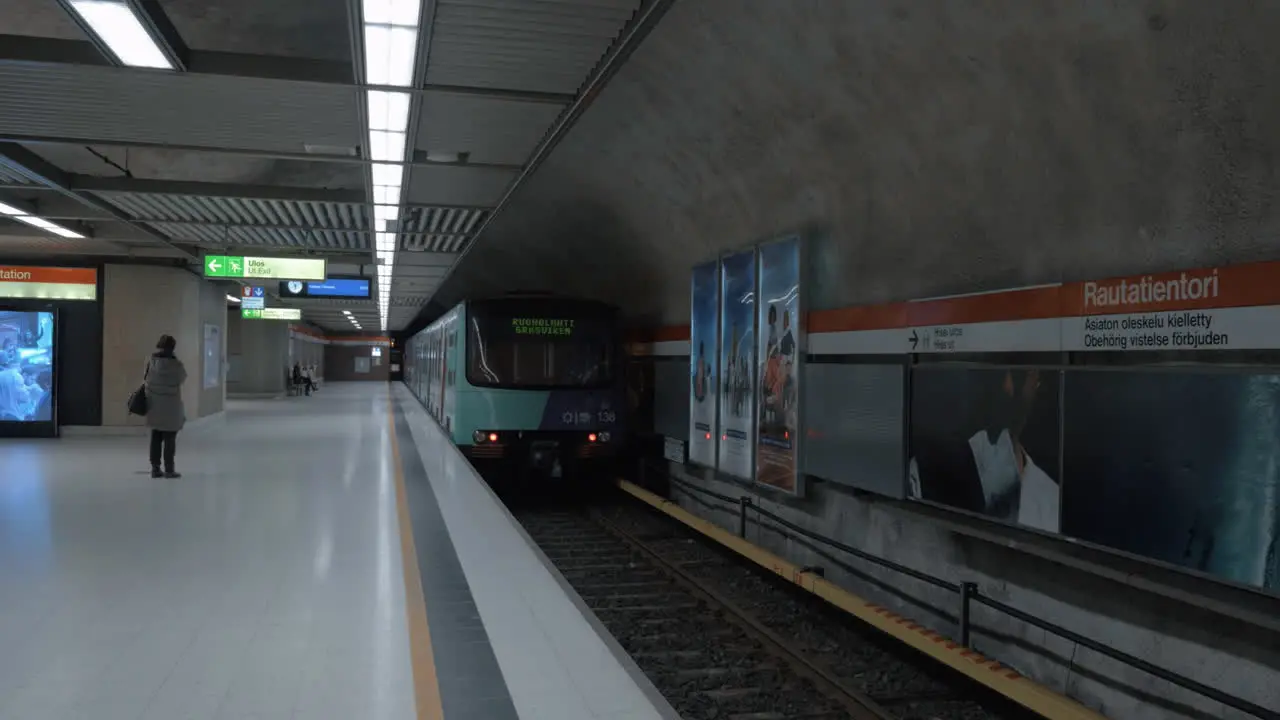 Subway station with few people and leaving train Helsinki Finland