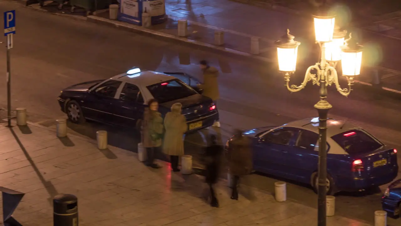 Timelapse of street with traffic and people at bus stop