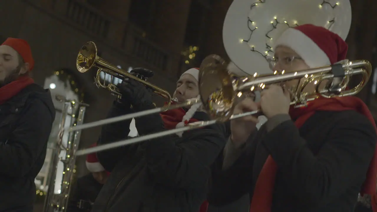 Street musicians dressed like Santa Claus plays on trumpets