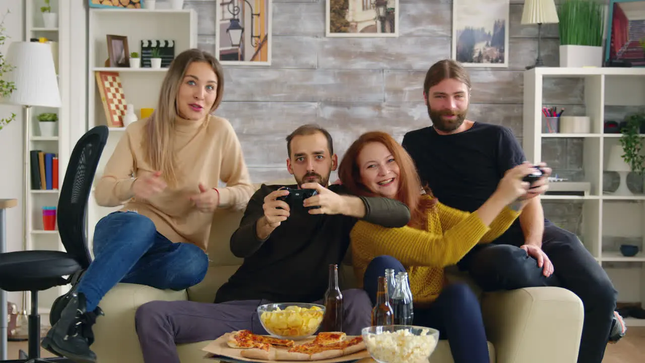 Excited man playing video games and trying to make her friend lose