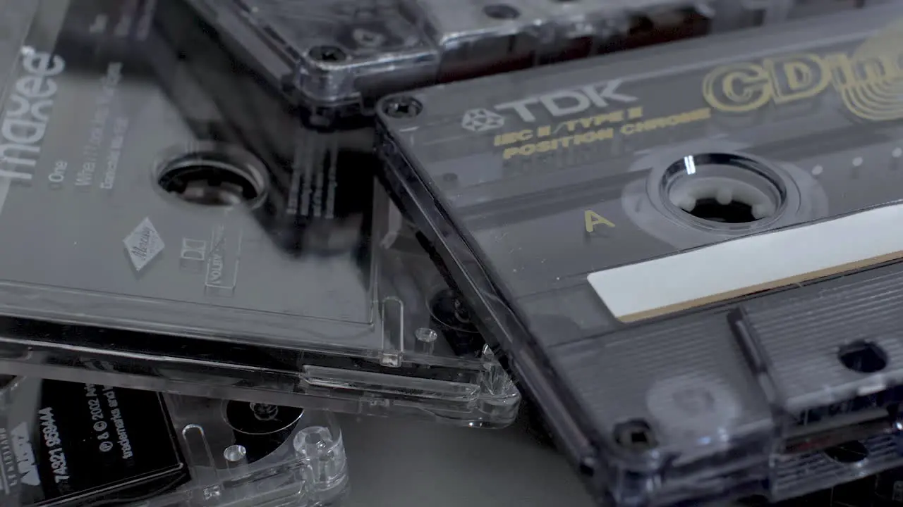 A close up shot panning across a stack of TDK cassette tapes tapes were a popular media for music and recordings in the early 80’s and 90’s