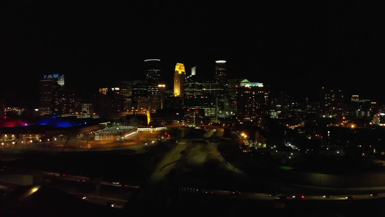 Aerial footage of downtown Minneapolis at night traffic crossing by